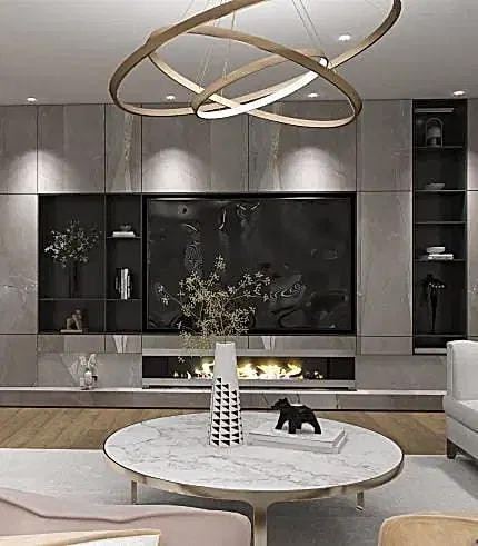 "Premium" koleksiyonunda dairesel avize, mermer yuvarlak masa, iç mimar tarafından küratörlüğü yapılan dekoratif vazolar ve şömineli minimalist bir taş duvar bulunan modern bir oturma odası yer alıyor. Kitaplarla dolu raflar ve dekor, villa veya çevrimiçi tasarım ilhamı için görünümü tamamlıyor.