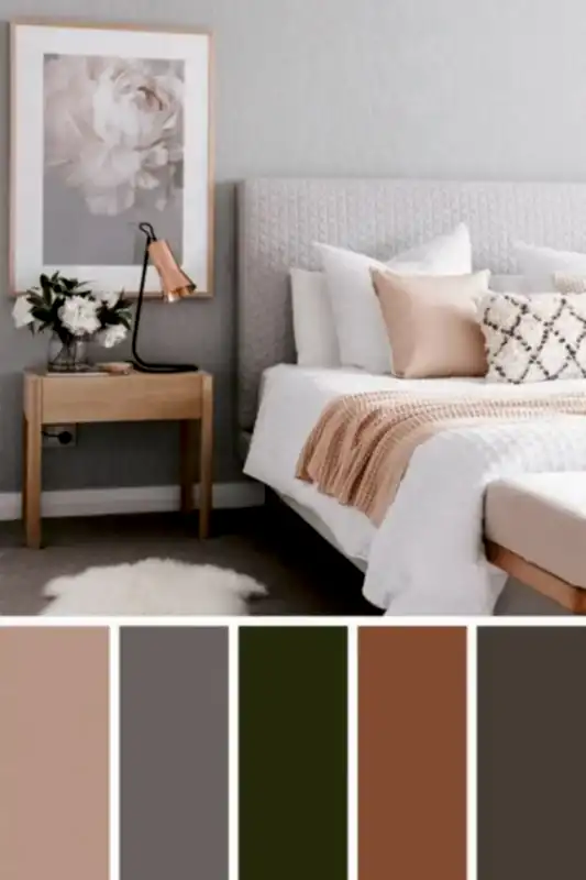 Huzurlu bir zarafet yansıtan yatak odasında gri döşemeli bir yatak başlığı, beyaz ve bej yatak takımı ve masa lambası ve çiçek aranjmanıyla süslenmiş ahşap bir komodin bulunmaktadır. Bej, gri, zeytin, kahverengi ve koyu gri renk paleti, bir iç mimarın tasarımının sofistike dokunuşunu yansıtır.