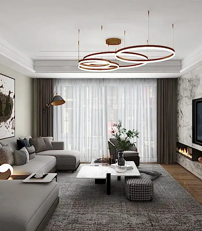 İç mimar tarafından tasarlanan, Standart gri oturma grubu, soyut sanat, yuvarlak sehpa ve gösterişli bir avize içeren modern oturma odası. Şeffaf perdelere sahip büyük pencereler, mermer duvara yerleştirilmiş doğrusal şömineyi tamamlıyor. Villa iç mekanları için ideal ilham.