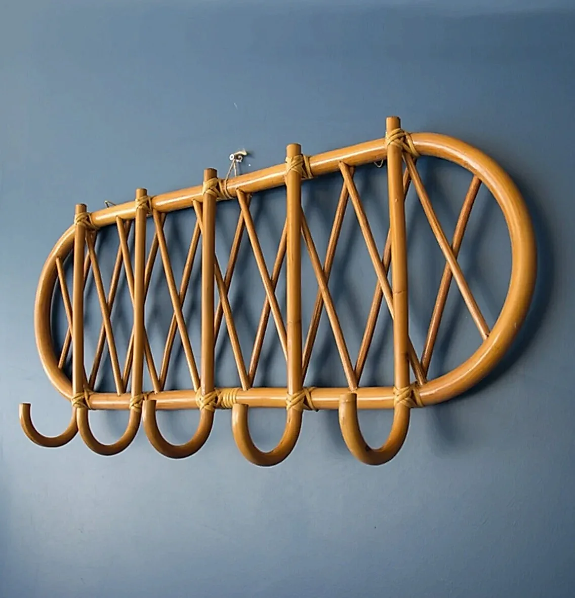 İç mimar tarafından tasarlanan bir villa için mükemmel olan, altı kancalı duvara monte bambu askılık, mavi bir fonun önünde öne çıkıyor.